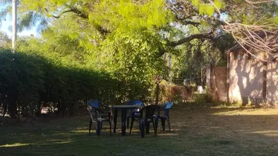 a table and chairs in the shade of a tree at Departamento en Nono Descanso y aventura in Nono