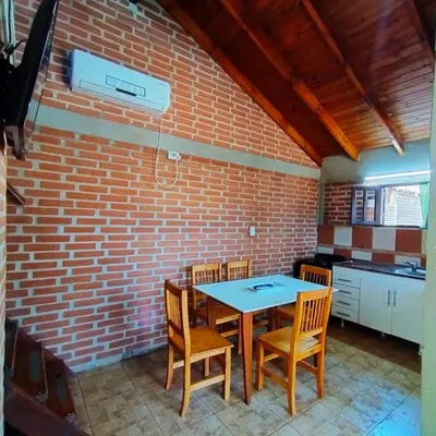 a kitchen with a brick wall and a table and chairs at Acogedora cabaña en el corazón de Nono in Nono