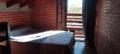 a bed in a room with a brick wall and a window at Acogedora cabaña en el corazón de Nono in Nono