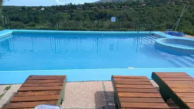 a large swimming pool with two benches in front of it at Sierra madre 2 in El Rincón