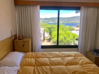 a bedroom with a bed and a large window at Casa Carlos Paz Terrazas del Lago in Villa Carlos Paz