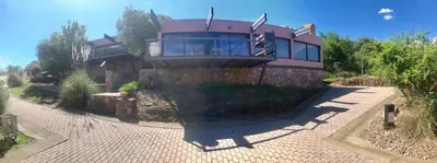 a large house on top of a stone wall at Casa Carlos Paz Terrazas del Lago in Villa Carlos Paz