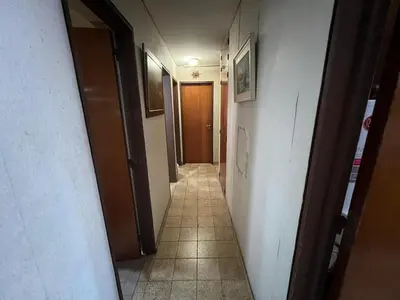 a hallway with a long corridor with doors and a tile floor at Amplio departamento en Cofico in Cordoba