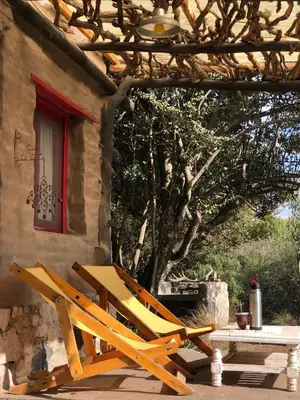 a wooden chair sitting outside of a house at Rancho Eco Loft in San Javier