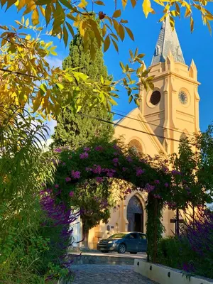 a church with a clock tower with purple flowers at Rancho Eco Loft in San Javier