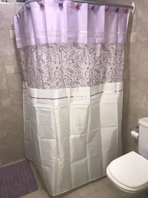 a bathroom with a shower curtain and a toilet at Fragancias Serranas in Cortaderas