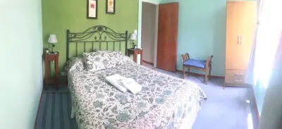 a bedroom with a bed with a comforter and two towels at Fragancias Serranas in Cortaderas