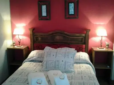 a bedroom with a bed with two lamps on two tables at Fragancias Serranas in Cortaderas