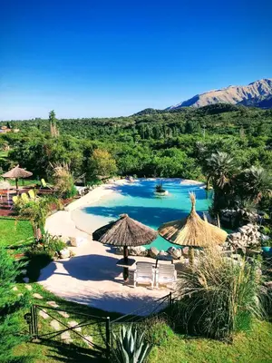 a large pool with chairs and umbrellas in a resort at Fragancias Serranas in Cortaderas