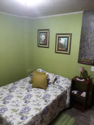 a bedroom with a bed and two pictures on the wall at Fragancias Serranas in Cortaderas