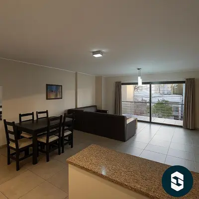 a living room with a table and a couch at Central Suites Hotel in Villa Carlos Paz