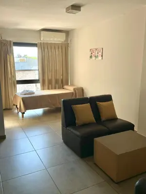 a living room with a couch and a bed at Central Suites Hotel in Villa Carlos Paz