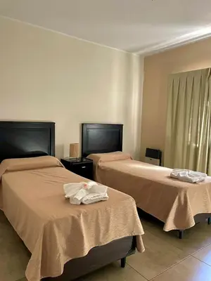 two beds sitting next to each other in a room at Central Suites Hotel in Villa Carlos Paz