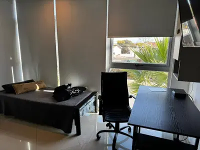 a bedroom with a bed and a chair and a window at LOFT Santa Rita in Villa Carlos Paz