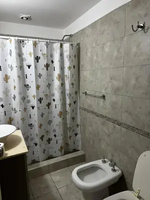a bathroom with a toilet and a shower curtain at LOFT Santa Rita in Villa Carlos Paz