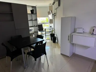 a kitchen with a table and chairs and a refrigerator at LOFT Santa Rita in Villa Carlos Paz