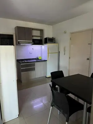 a kitchen with a black table and a refrigerator at LOFT Santa Rita in Villa Carlos Paz