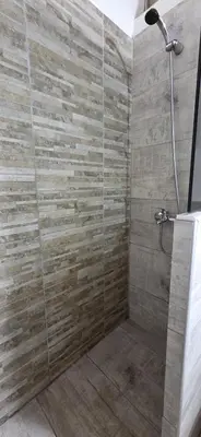 a bathroom with a shower with a stone wall at monoamb moderno in Cordoba