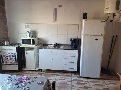 a kitchen with a white refrigerator and a microwave at Confortable Casa con Pileta, Parrilla y Patio in Cruz de Caña