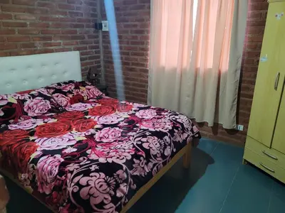 a bedroom with a bed with a floral comforter at Confortable Casa con Pileta, Parrilla y Patio in Cruz de Caña