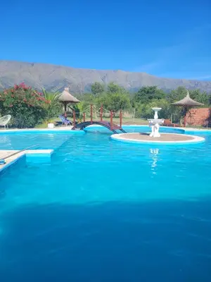 a large swimming pool with a fountain in the middle at Confortable Casa con Pileta, Parrilla y Patio in Cruz de Caña