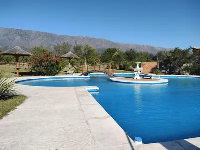 a large swimming pool with a playground and a water slide at Confortable Casa con Pileta, Parrilla y Patio in Cruz de Caña