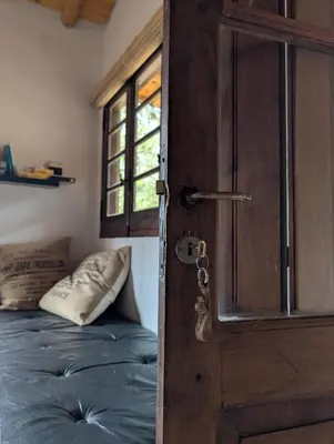 an open door with a bed in a bedroom at Cabañas Terra in Villa Yacanto