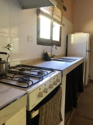 a kitchen with a stove top oven and a refrigerator at Cabañas Terra in Villa Yacanto