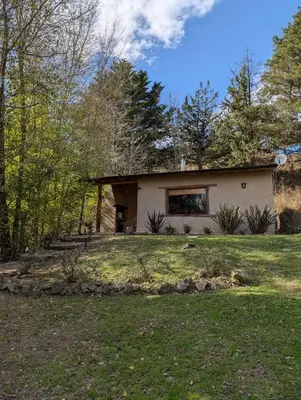 a house in the middle of a yard at Cabañas Terra in Villa Yacanto