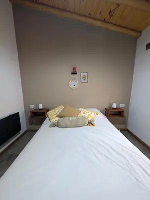 a bedroom with a large white bed in a room at Cabañas Terra in Villa Yacanto