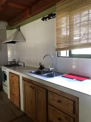 a kitchen with a sink and a stove at Cabañas Terra in Villa Yacanto
