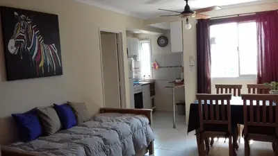 a living room with a couch and a dining room at Departamento Temporario Villa Sol in Cordoba