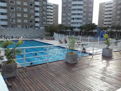 a swimming pool with people sitting in the water at Departamento Temporario Villa Sol in Cordoba