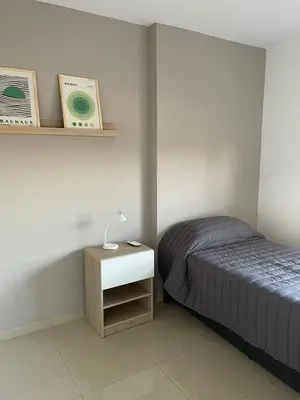 a bedroom with a bed and a night stand with a lamp at MILANO 2d2b - RF - Gral Paz - Hogares de Calidad in Cordoba