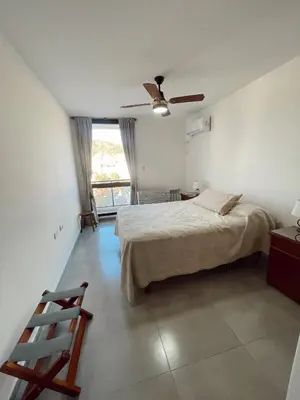 a bedroom with a bed and a ceiling fan at Departamento 1 dormitorio in Villa Carlos Paz