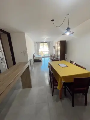 a dining room with a yellow table and chairs at Departamento 1 dormitorio in Villa Carlos Paz