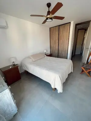 a bedroom with a bed and a ceiling fan at Departamento 1 dormitorio in Villa Carlos Paz