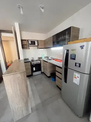 a kitchen with a stainless steel refrigerator and cabinets at Departamento 1 dormitorio in Villa Carlos Paz