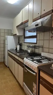 a kitchen with a stove and a refrigerator at Edificio ALEM CENTRO in Villa Carlos Paz