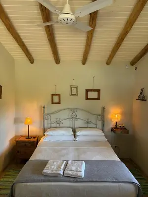 a bedroom with a bed with two pillows and a ceiling at La Cambicha Ranchos in Los Reartes