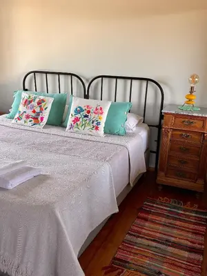 a bedroom with a bed with pillows and a night stand at La Cambicha Ranchos in Los Reartes