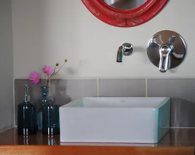 a white sink and a mirror and some bottles at La Cambicha Ranchos in Los Reartes