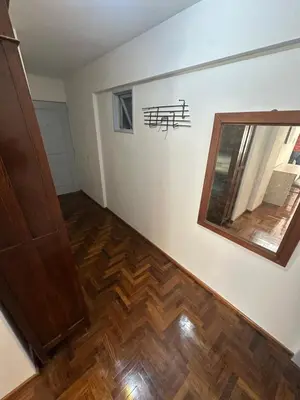 a room with a wooden floor and a mirror at Estrada Apart in Cordoba