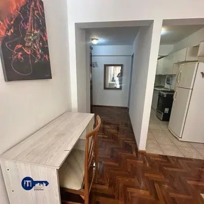 a kitchen with a wooden table and a refrigerator at Estrada Apart in Cordoba