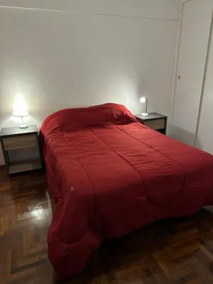 a red bed in a room with two night stands at Estrada Apart in Cordoba