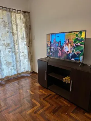 a living room with a flat screen tv on a cabinet at Estrada Apart in Cordoba