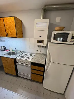 a small kitchen with a stove and a microwave at Apartamento en Pleno Nueva Córdoba, Garzon, By ApartCba in Cordoba