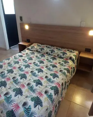 a bedroom with a bed with a floral bedspread at Casas Mya in Santa Rosa de Calamuchita