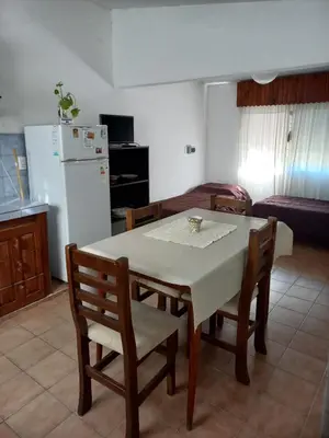 a kitchen with a table and chairs and a refrigerator at Casas Mya in Santa Rosa de Calamuchita