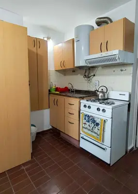 a kitchen with a white stove and wooden cabinets at El Depto del Rey in Cordoba